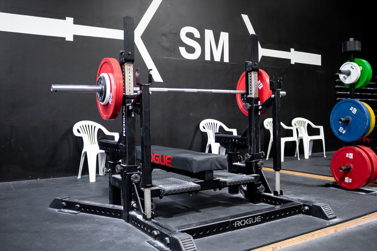 Loaded Rogue combo rack set up for bench press at Strength Metrics Gym