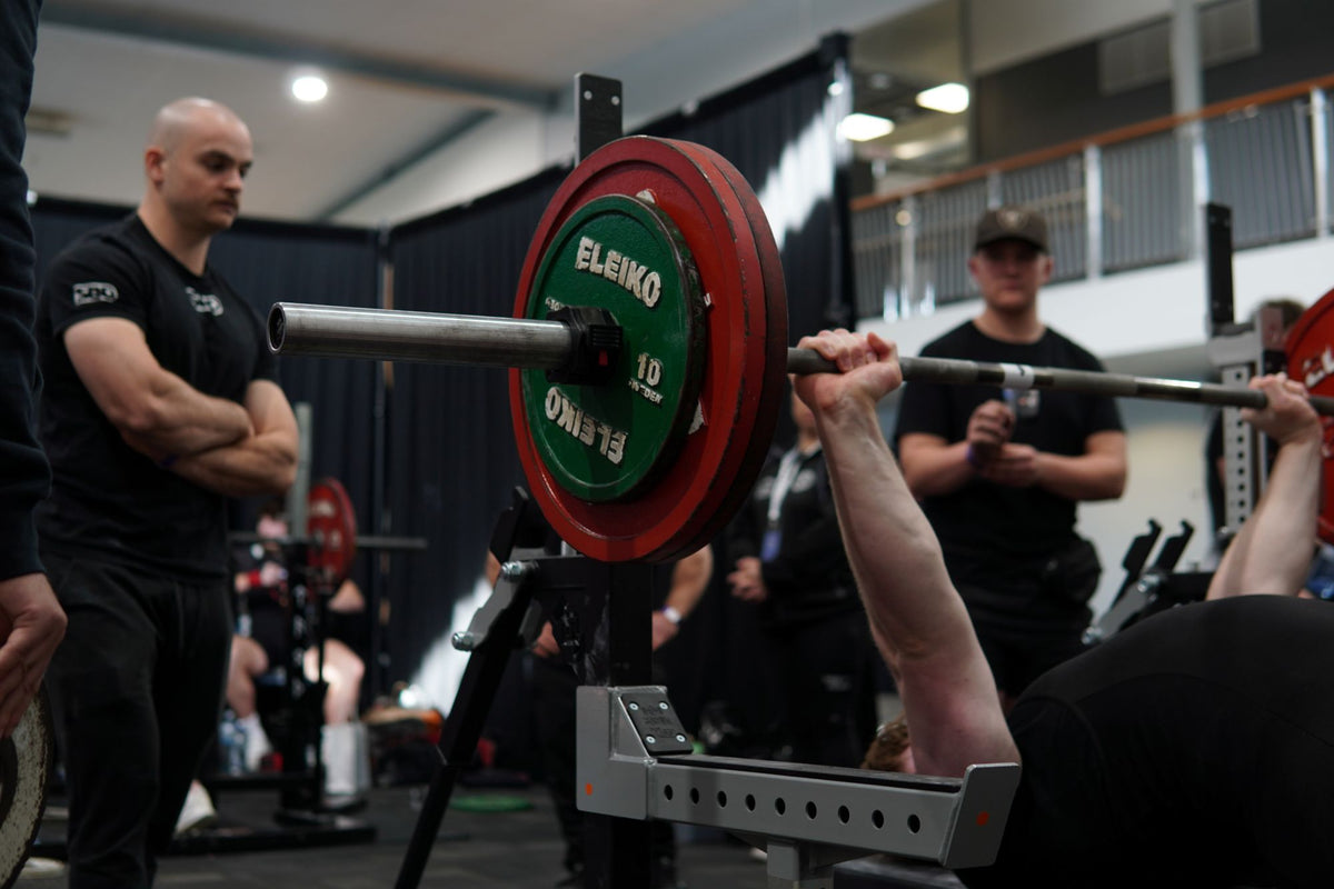 Coaches watching a lifter bench press